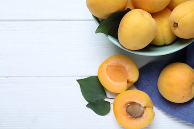 Delicious fresh ripe apricots on white wooden table, flat lay. Space for text