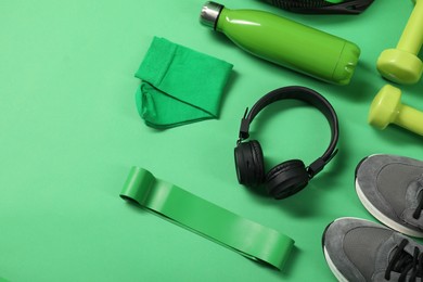 Different sports equipment on green background, flat lay. Space for text