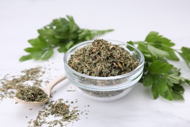 Dried aromatic parsley and fresh leaves on white table