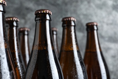 Bottles of beer on grey background, closeup. Space for text
