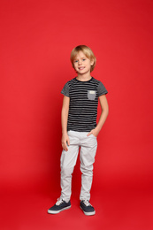 Photo of Full length portrait of cute little boy on red background