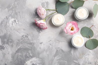 Photo of Flat lay composition with hand cream jars and space for text on gray background