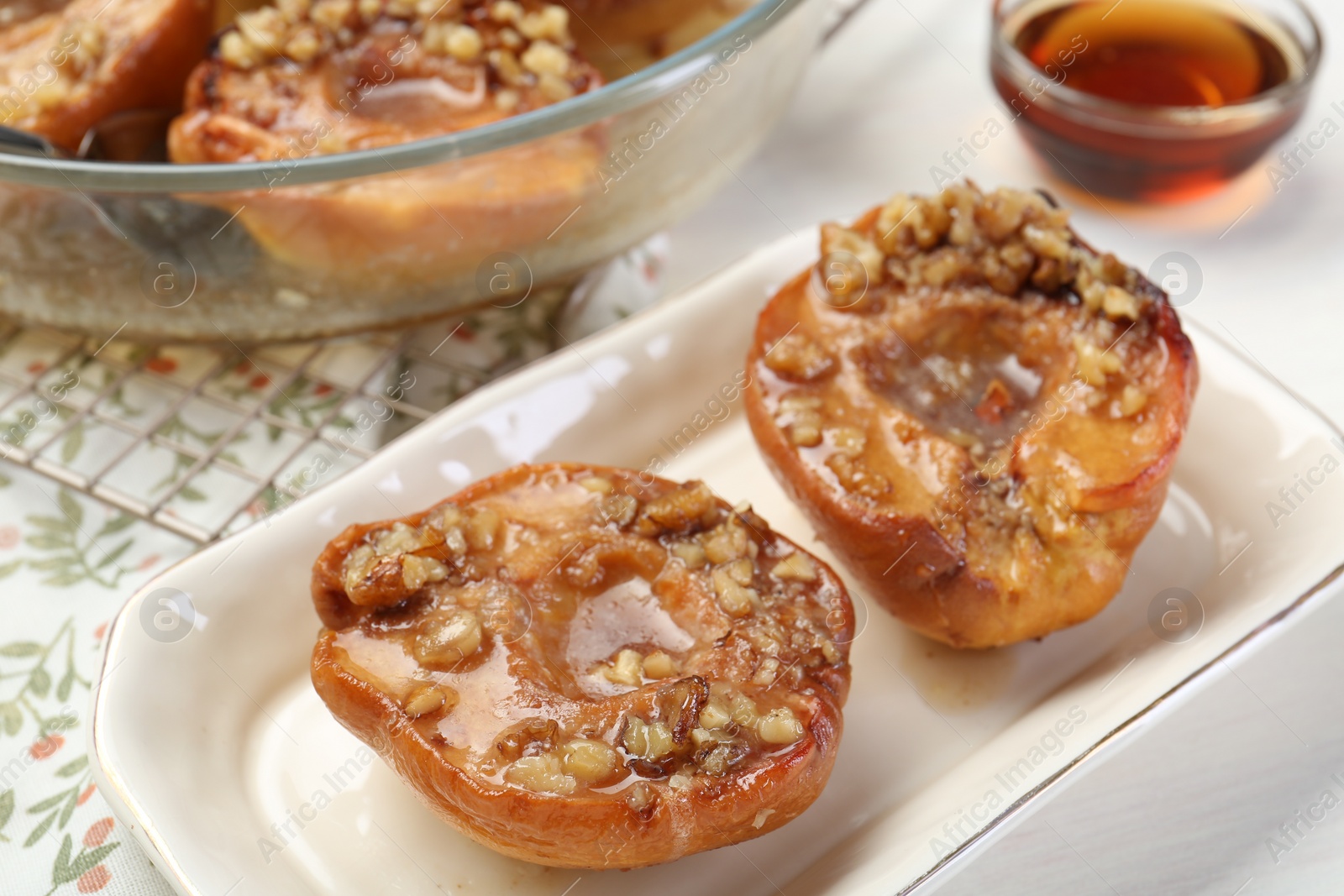 Photo of Delicious quinces baked with honey and walnuts on white table, closeup