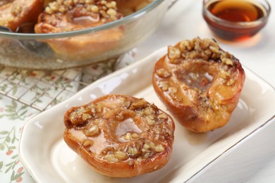 Delicious quinces baked with honey and walnuts on white table, closeup