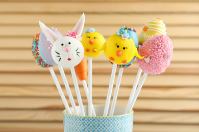 Photo of Different delicious sweet cake pops on wooden background. Easter holiday
