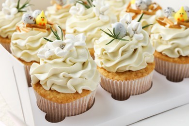 Tasty Easter cupcakes with vanilla cream in box, closeup