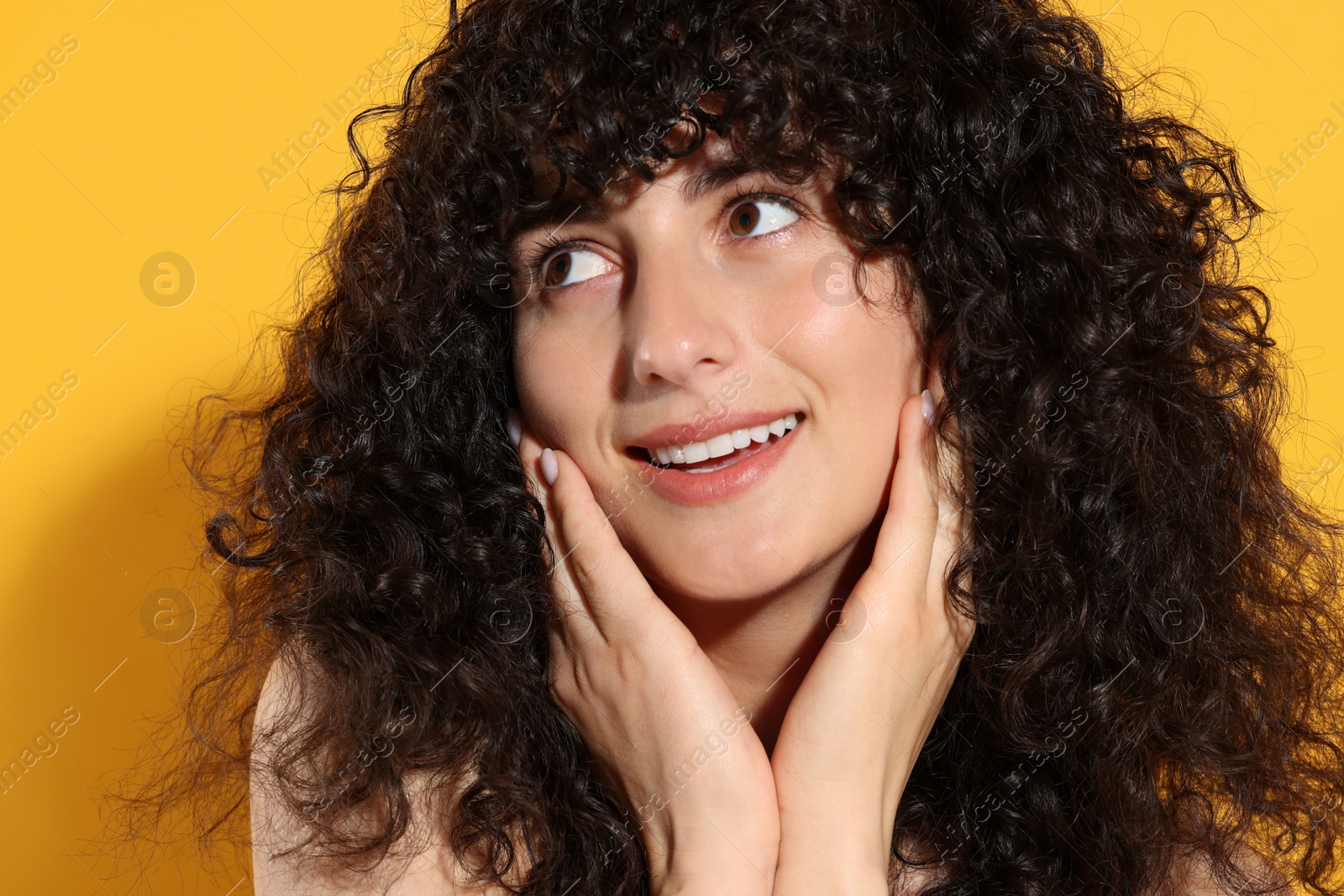 Photo of Beautiful young woman in sunlight on orange background