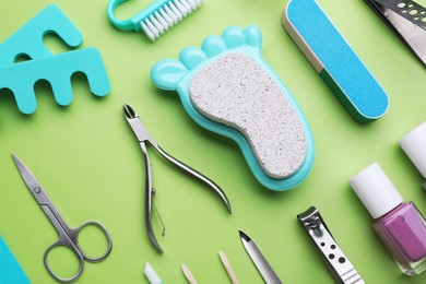 Photo of Setpedicure tools on light green background, flat lay
