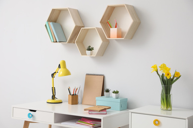 Photo of Comfortable workplace with wooden furniture and lamp