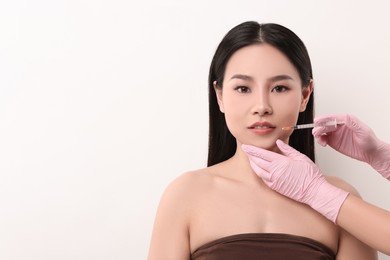 Photo of Woman getting lip injection on white background