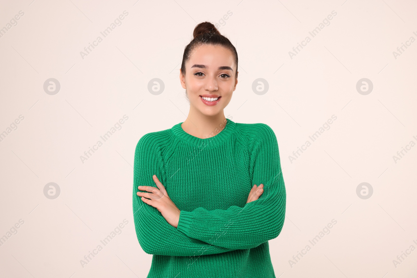 Photo of Beautiful young woman in stylish warm sweater on light grey background
