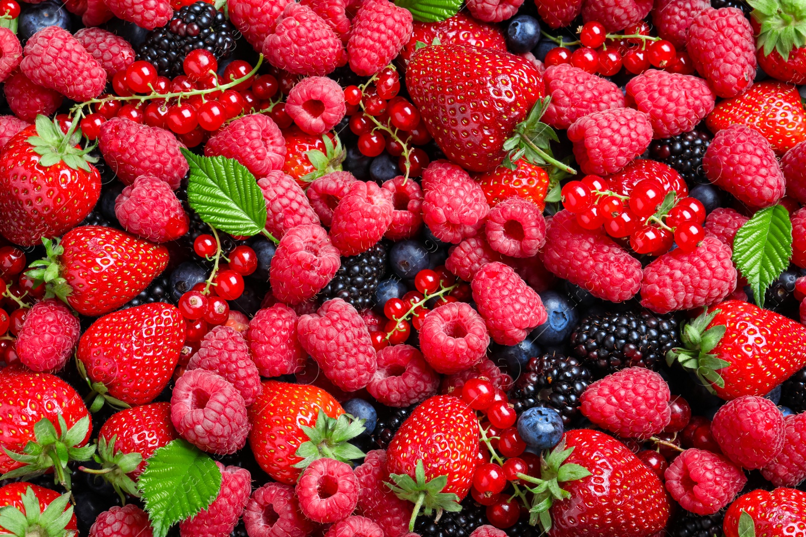 Photo of Mix of different ripe tasty berries as background, top view