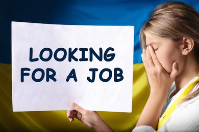 Unemployed due to war. Sad woman holding sign with phrase Looking For A Job against Ukrainian flag
