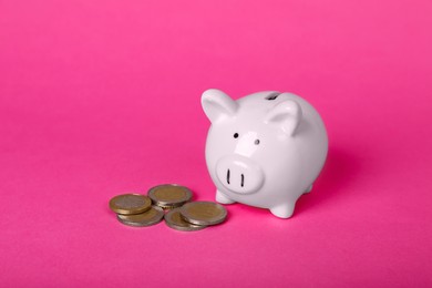 Ceramic piggy bank and coins on pink background. Financial savings