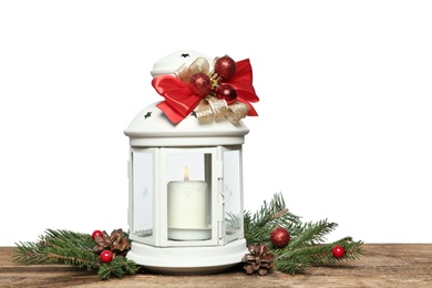 Photo of Christmas lantern with burning candle and decor on wooden table