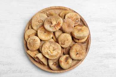 Photo of Tasty dried figs on white wooden table, top view
