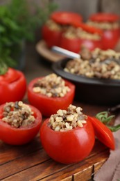 Photo of Delicious stuffed tomatoes with minced beef, bulgur and mushrooms on wooden table
