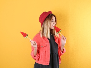 Young pretty woman with candies on colorful background