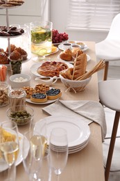 Variety of snacks on wooden table in buffet style indoors