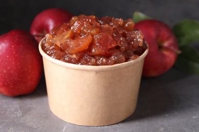 Photo of Delicious apple jam and fresh fruits on grey table, closeup