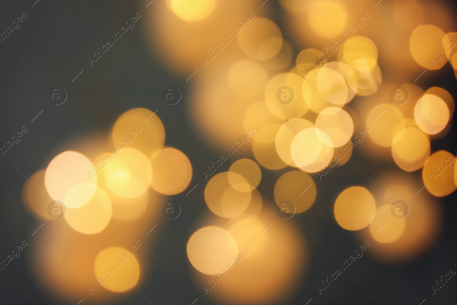 Photo of Blurred view of gold lights on dark background. Bokeh effect