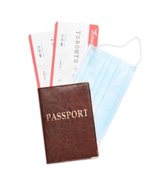 Photo of Passport, tickets and protective mask on white background, top view. Travel during quarantine