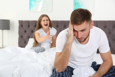 Photo of Young couple arguing in bedroom. Relationship problems