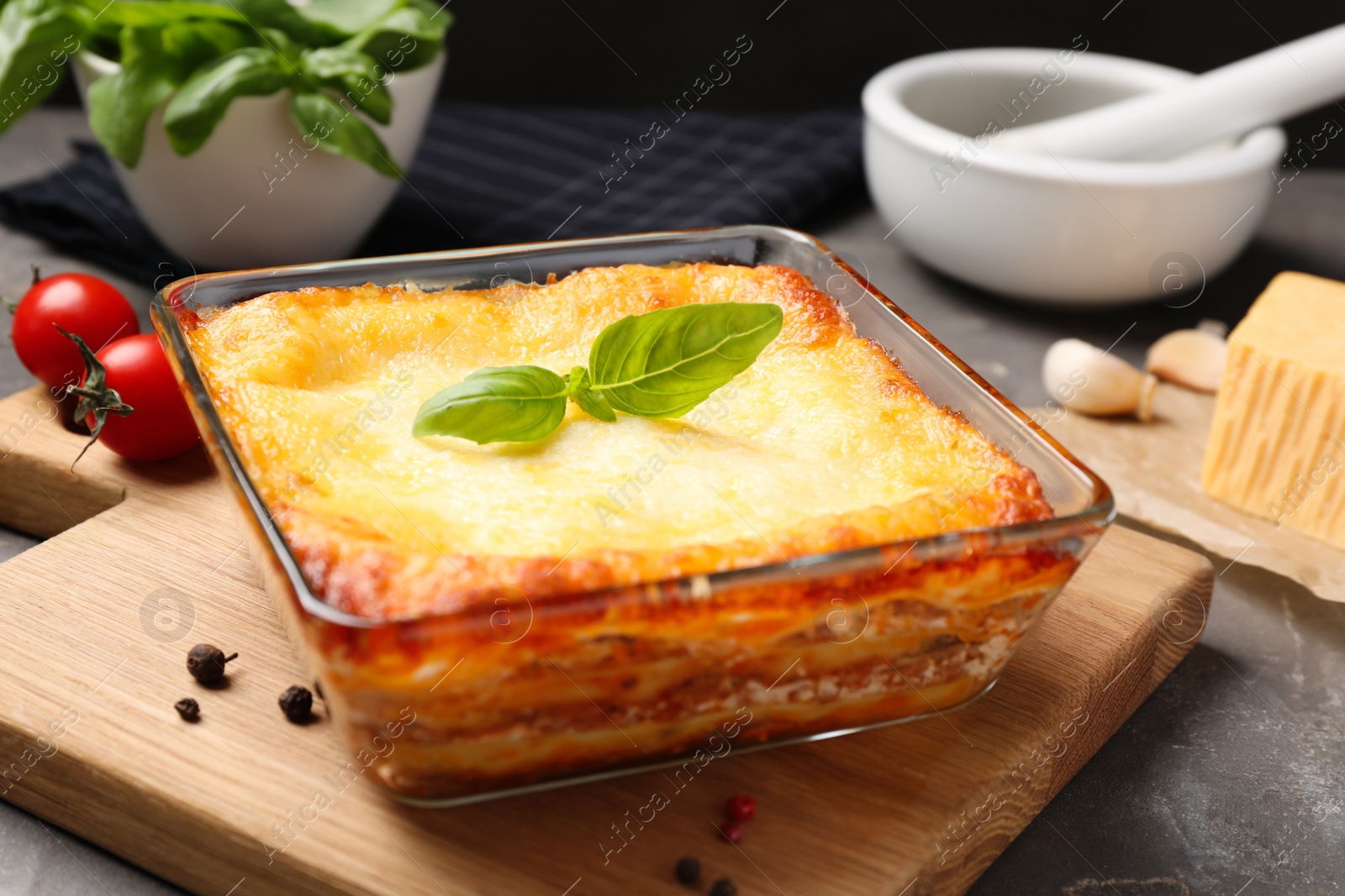Photo of Tasty cooked lasagna in baking dish on grey table, closeup