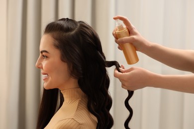 Photo of Hair styling. Professional hairdresser working with smiling client in salon, closeup