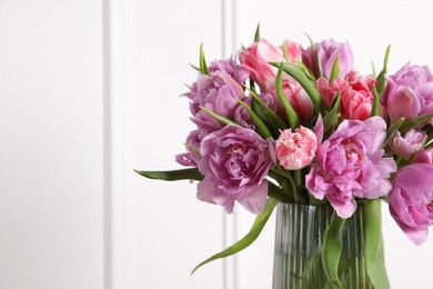 Photo of Beautiful bouquet of colorful tulip flowers in vase on white background