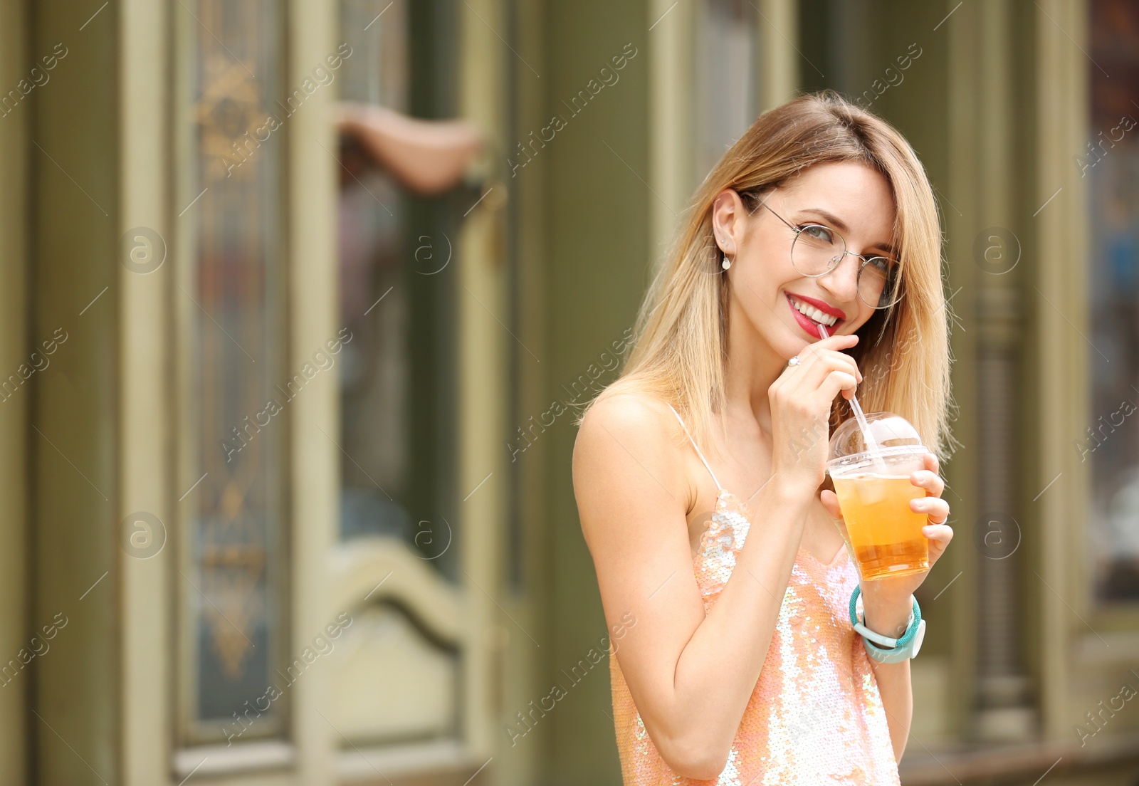 Photo of Young woman with cup of tasty lemonade outdoors