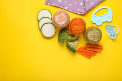 Photo of Flat lay composition with glass jars of healthy baby food and ingredients on yellow background. Space for text