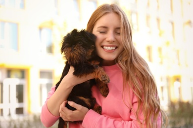 Photo of Young woman with adorable Brussels Griffon dog outdoors