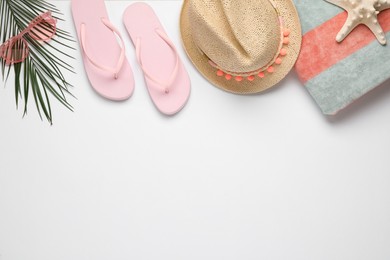 Photo of Beach towel, flip flops, hat and sunglasses on white background, flat lay. Space for text