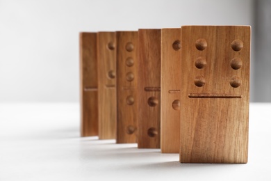 Beautiful wooden dominoes on white table, closeup