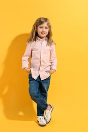 Photo of Fashion concept. Stylish girl posing on yellow background