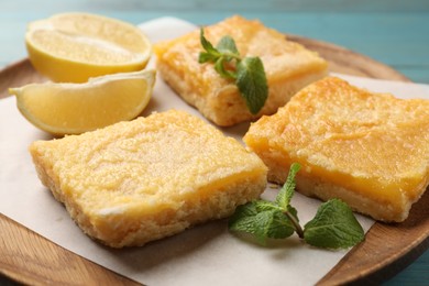 Photo of Tasty lemon bars and mint on table, closeup