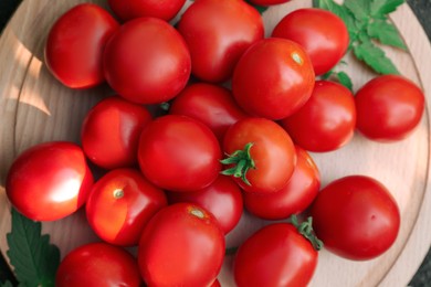 Wooden board with fresh ripe tomatoes, top view