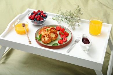 Delicious cottage cheese pancakes with fresh berries and mint served on white bed tray