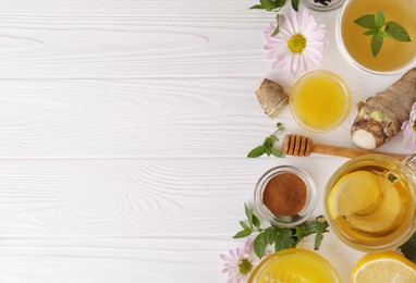 Flat lay composition with cup of delicious tea, honey and ginger on white wooden table. Space for text