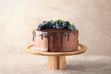 Photo of Fresh delicious homemade chocolate cake with berries on table against color background