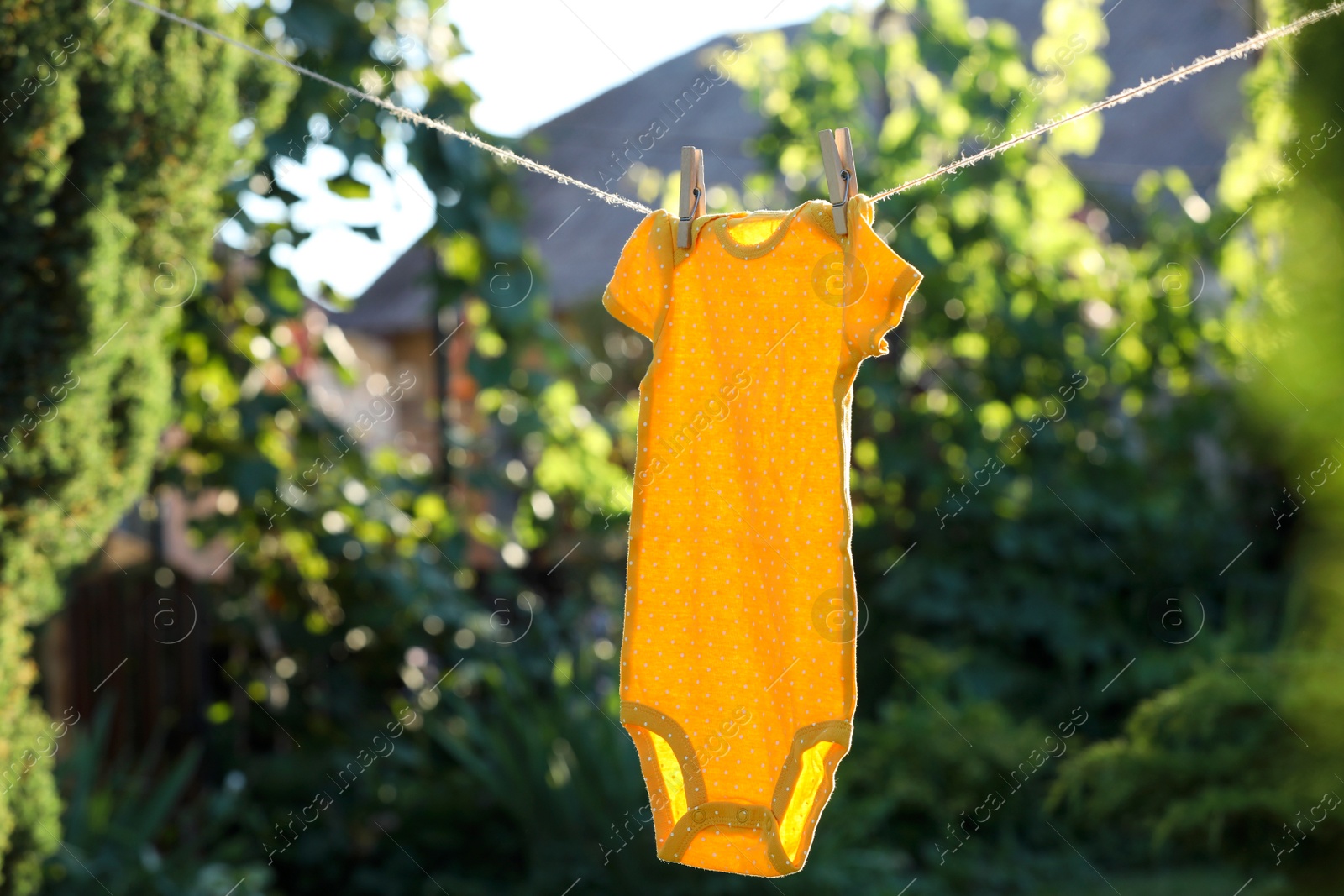 Photo of Baby bodysuit drying on washing line outdoors