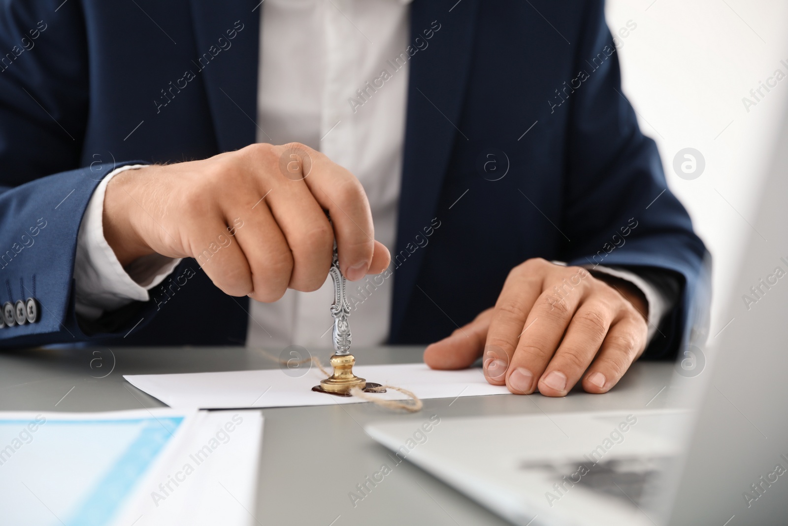 Photo of Notary stamping document at desk in office, closeup