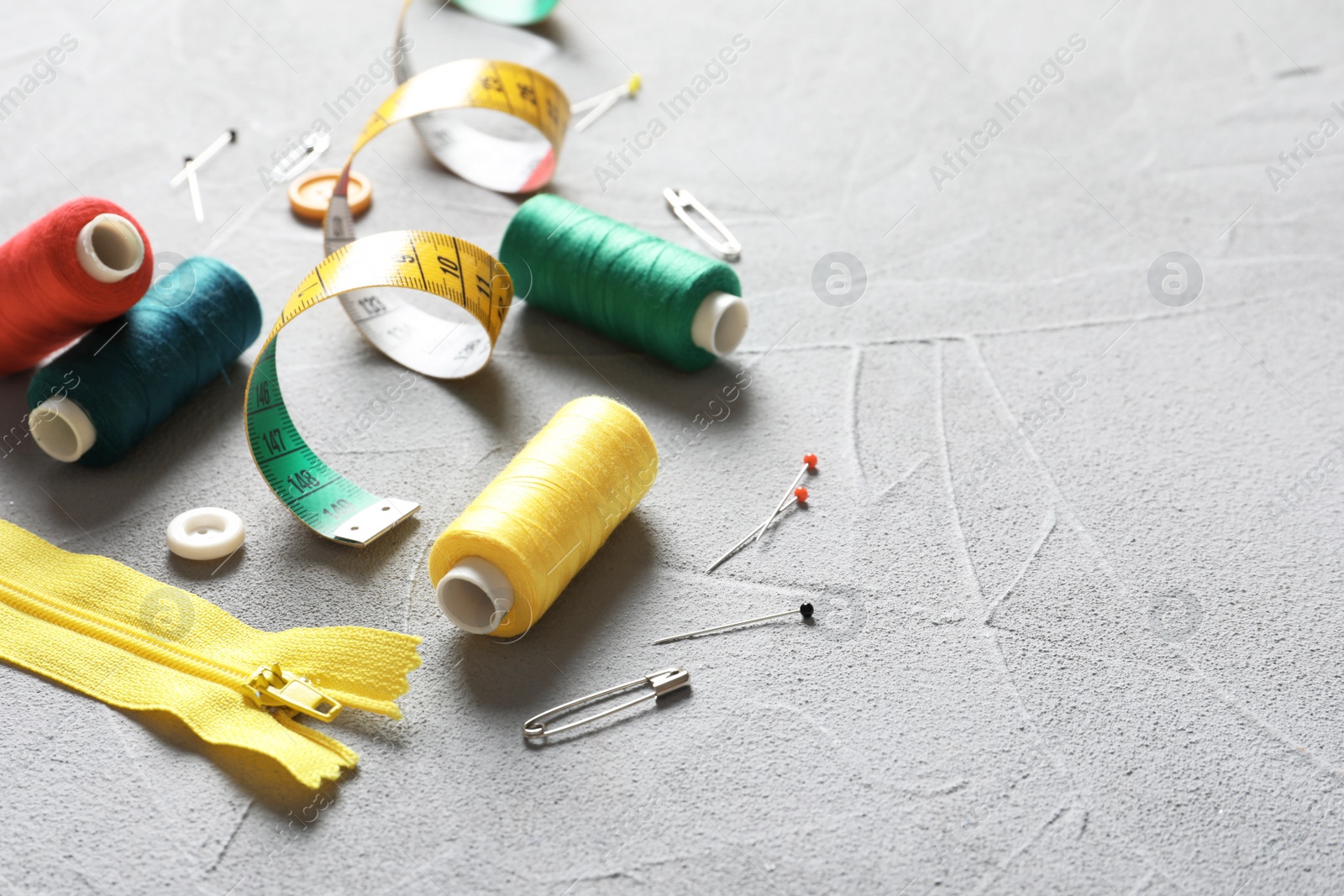 Photo of Set of tailoring accessories on grey background