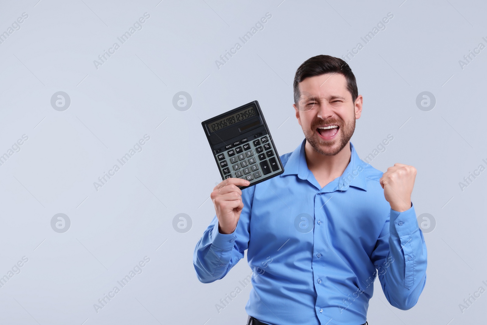 Photo of Emotional accountant with calculator on light grey background. Space for text