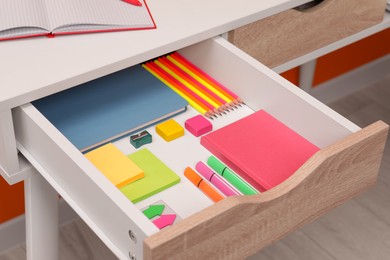 Photo of Office supplies in open desk drawer indoors