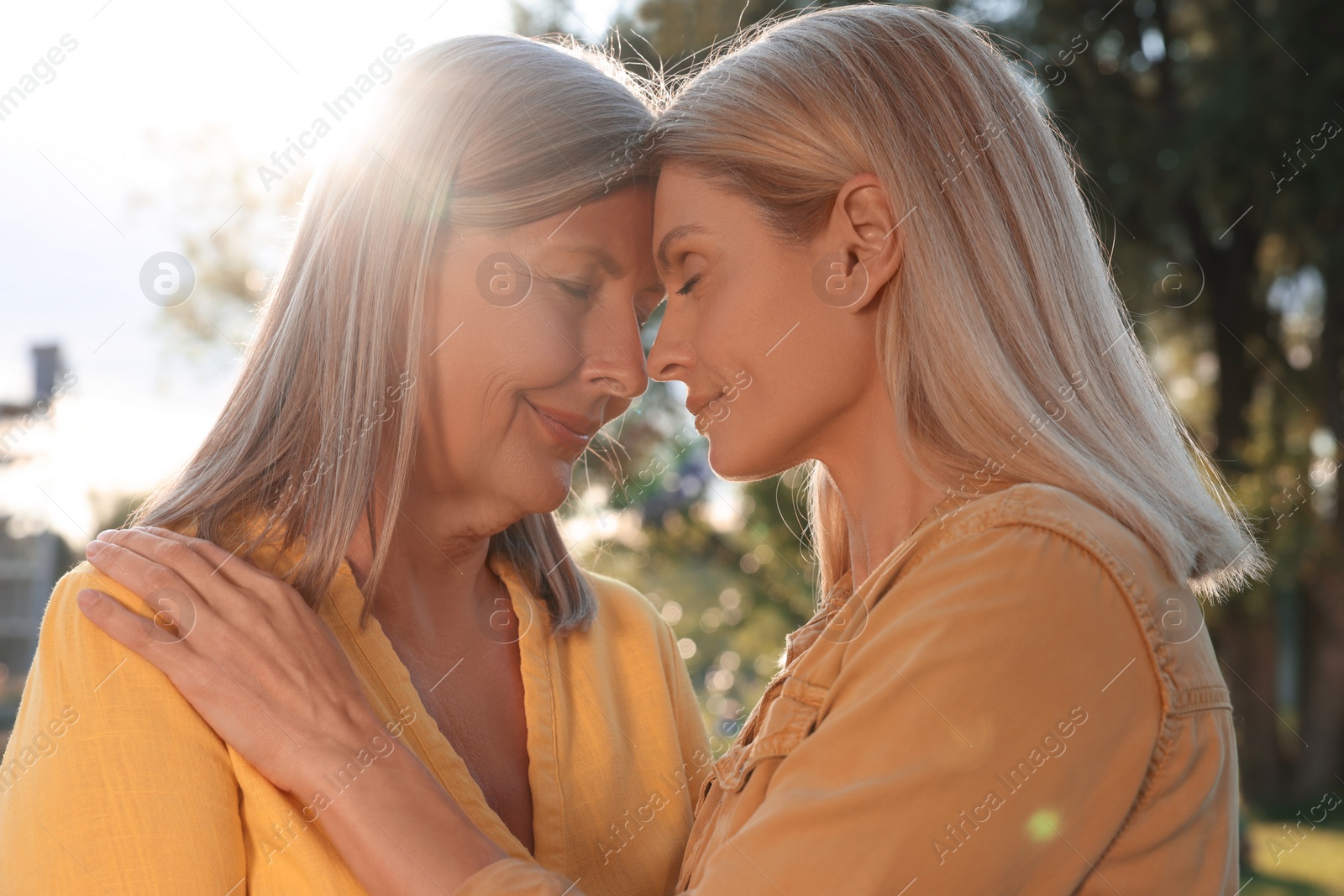 Photo of Family portrait of happy mother and daughter spending time together outdoors on sunny day