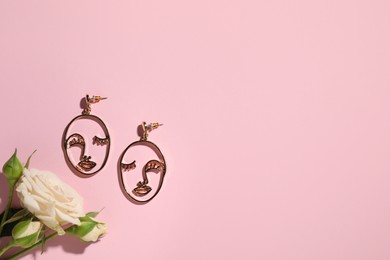 Photo of Beautiful earrings and rose on pink background, flat lay. Space for text