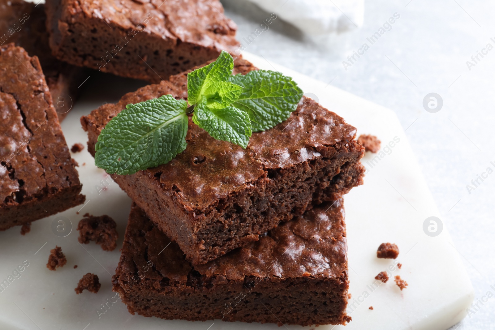 Photo of Delicious chocolate brownies with fresh mint on table, closeup