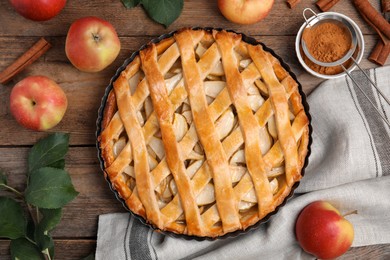 Delicious traditional apple pie on wooden table, flat lay